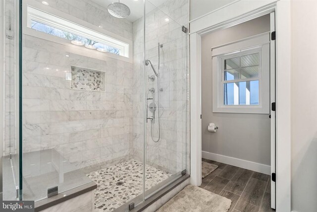  - bathroom with a shower stall and wood tiled floors