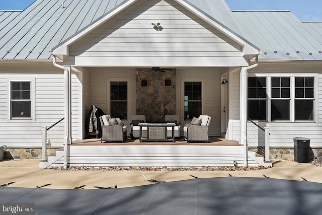  - rear view of property with an outdoor living space, a standing seam roof, a ceiling fan, and a metal roof
