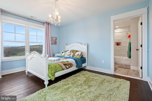  - bedroom with dark wood-style flooring, a chandelier, and ensuite bathroom