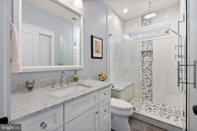  - bathroom featuring a shower stall, vanity, and wood finished floors