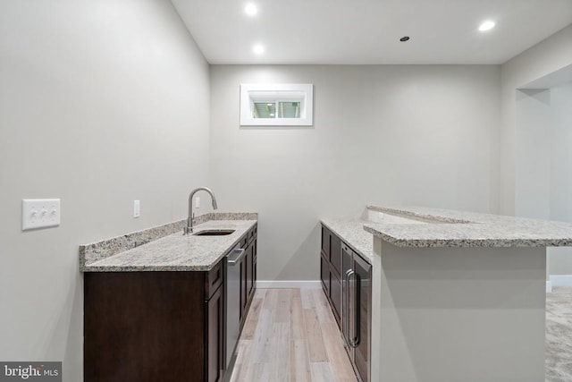  - kitchen featuring dark brown cabinetry, light stone countertops, a peninsula, recessed lighting, and stainless steel dishwasher