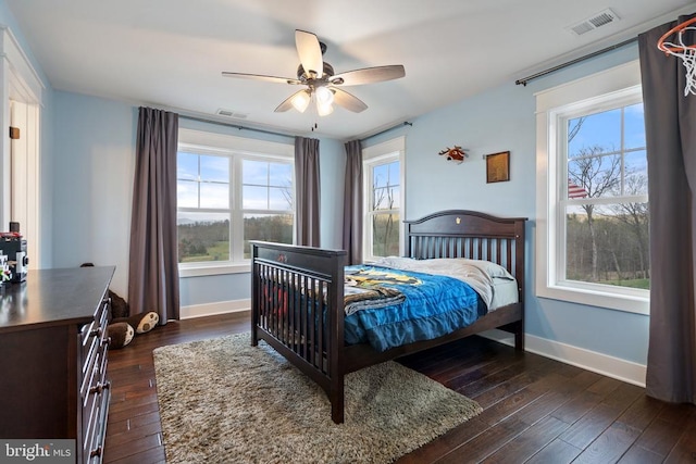  - bedroom with dark wood-style floors, multiple windows, and ceiling fan