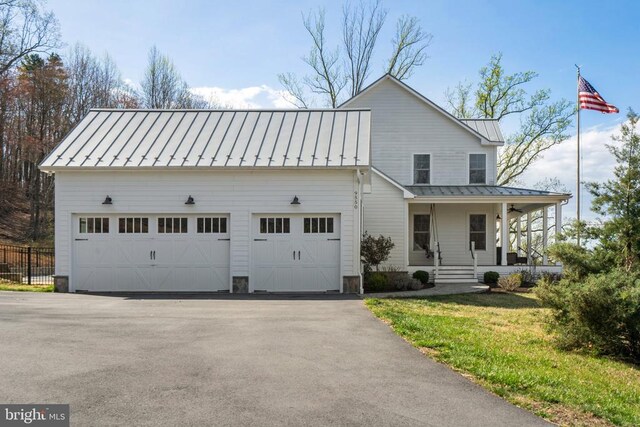  - view of front of home with a standing seam roof, covered porch, a metal roof, and a garage