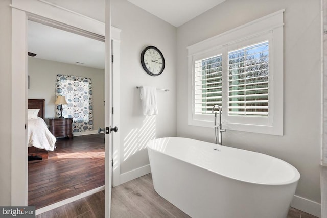  - ensuite bathroom featuring wood finished floors and a soaking tub