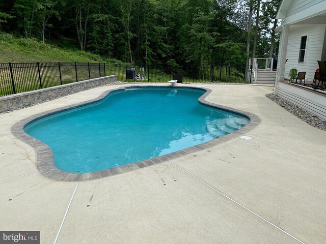  - view of pool featuring a patio area, a fenced backyard, and a wooded view