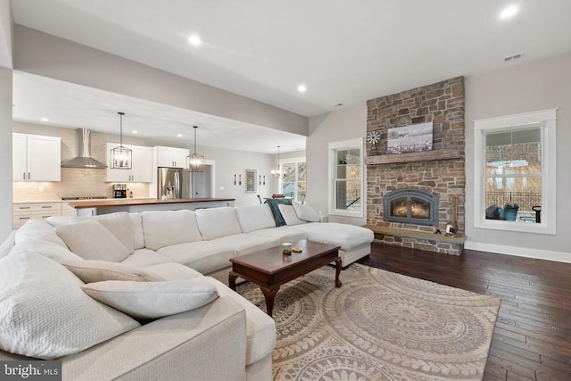  - living area with dark wood-style floors, recessed lighting, and a stone fireplace