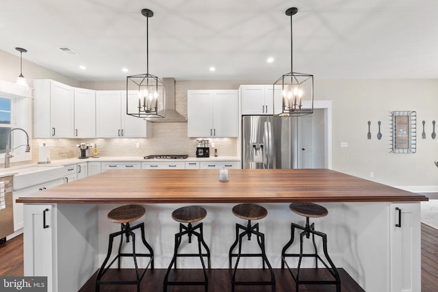  - kitchen with appliances with stainless steel finishes, wooden counters, a chandelier, and recessed lighting
