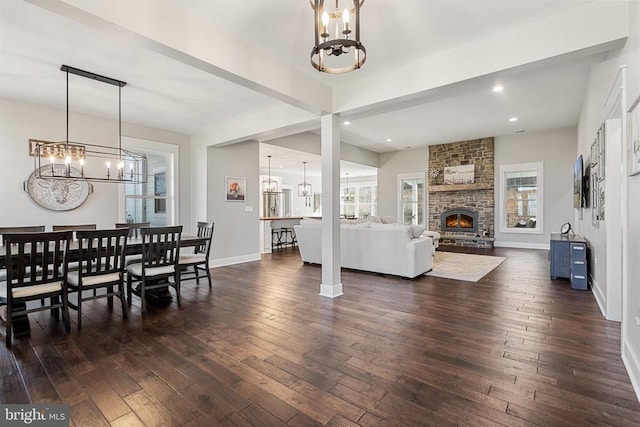  - dining area featuring a chandelier, dark wood-style flooring, a fireplace, and recessed lighting