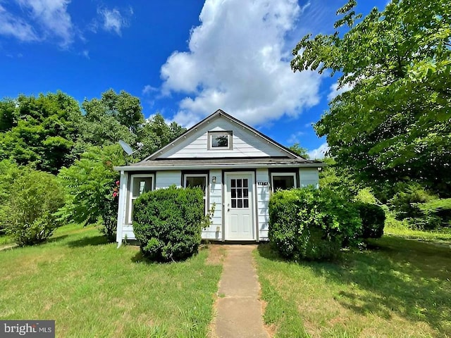 bungalow-style house featuring a front lawn