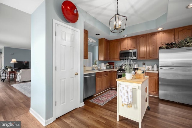9301 Glascow Dr, Fredericksburg, VA 22408 - kitchen with appliances with stainless steel finishes, a chandelier, dark wood-type flooring, brown cabinetry, and hanging light fixtures