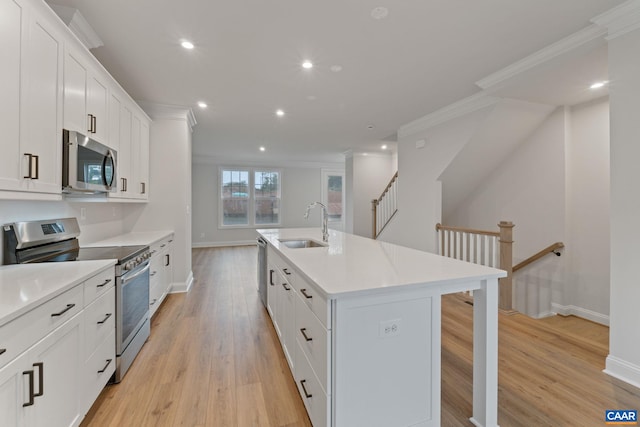 27 Woodburn Rd, Charlottesville, VA 22901 - kitchen with appliances with stainless steel finishes, crown molding, recessed lighting, light wood-type flooring, and an island with sink