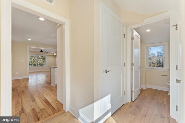 hallway with light hardwood / wood-style floors