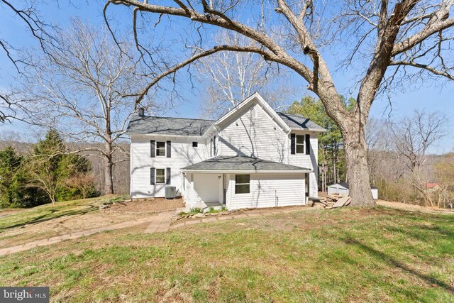 view of front facade featuring central AC and a front yard