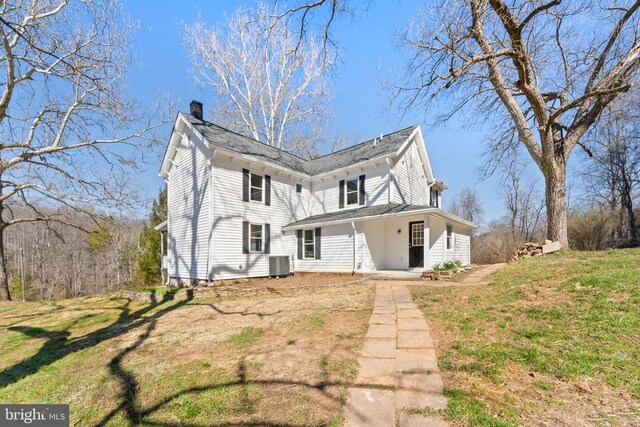 back of house featuring central AC, a porch, and a lawn