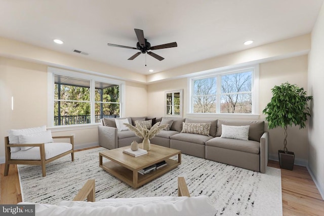 living room with ceiling fan and light hardwood / wood-style flooring