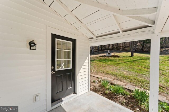 property entrance featuring a lawn