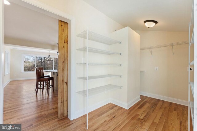 spacious closet featuring hardwood / wood-style flooring and lofted ceiling