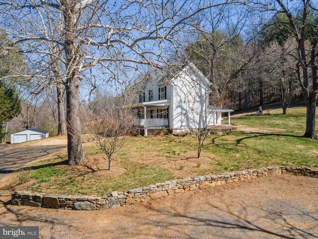 view of front of property with a garage, covered porch, and a front yard