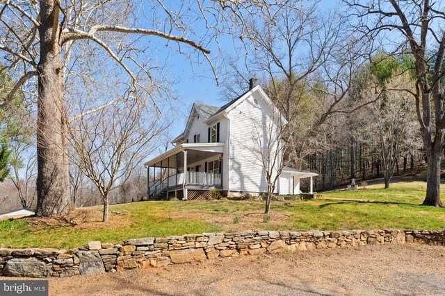 exterior space featuring a porch and a yard