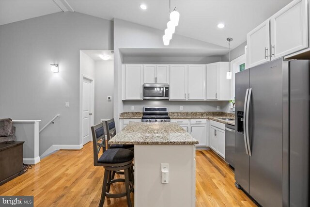 109 Poplar Dr, Louisa, VA 23093 - kitchen with stainless steel appliances, vaulted ceiling, white cabinets, light wood-style flooring, and light stone countertops