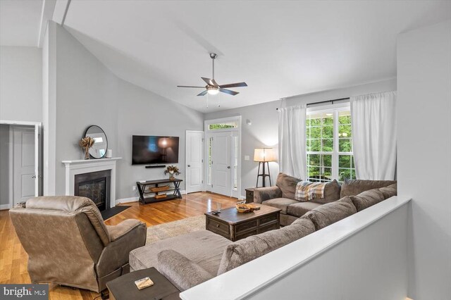 109 Poplar Dr, Louisa, VA 23093 - living room featuring wood finished floors, a ceiling fan, a fireplace with flush hearth, and high vaulted ceiling
