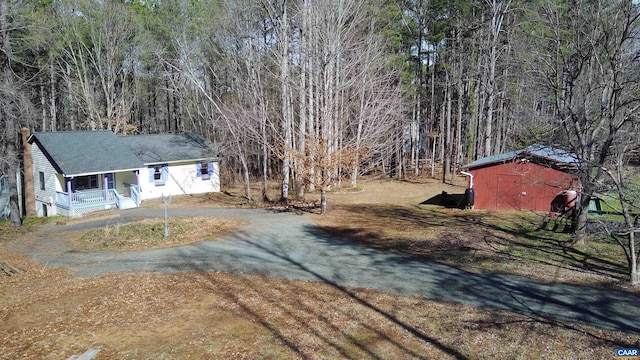3264 Martin Kings Rd, Charlottesville, VA 22903 - view of yard featuring driveway, an outbuilding, a forest view, a porch, and a storage shed