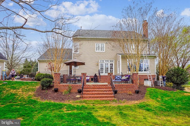 rear view of property featuring a chimney, a lawn, brick siding, and central air condition unit