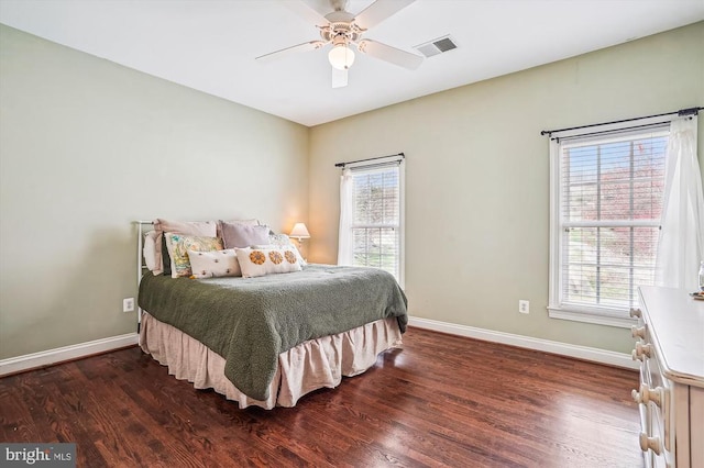 bedroom with baseboards, multiple windows, wood finished floors, and ceiling fan