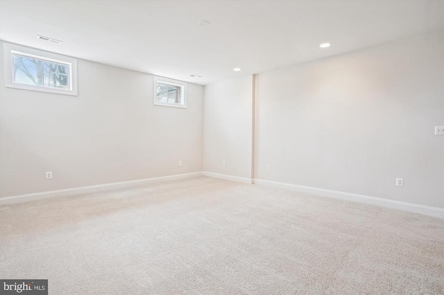 basement with baseboards, light colored carpet, and recessed lighting