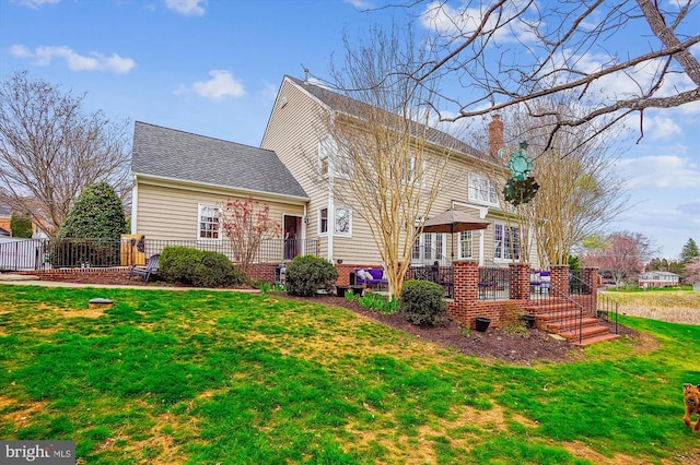 view of front of home with a chimney, a front lawn, and a shingled roof