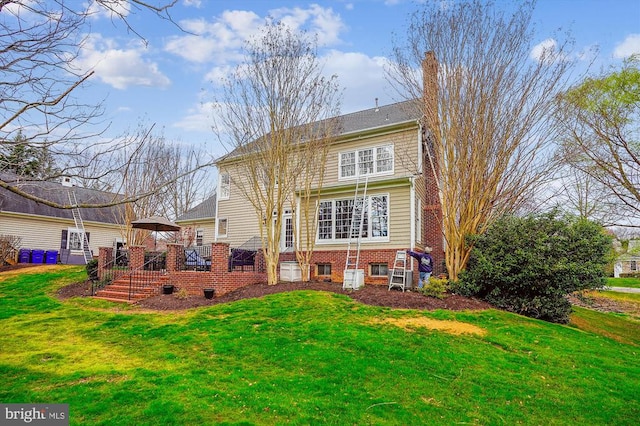 rear view of property with a yard and a deck