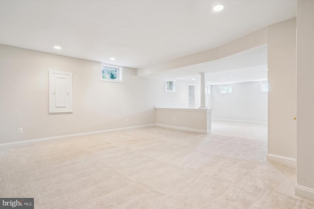 below grade area featuring light carpet, recessed lighting, and baseboards