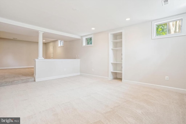 below grade area featuring light carpet, baseboards, plenty of natural light, recessed lighting, and built in features