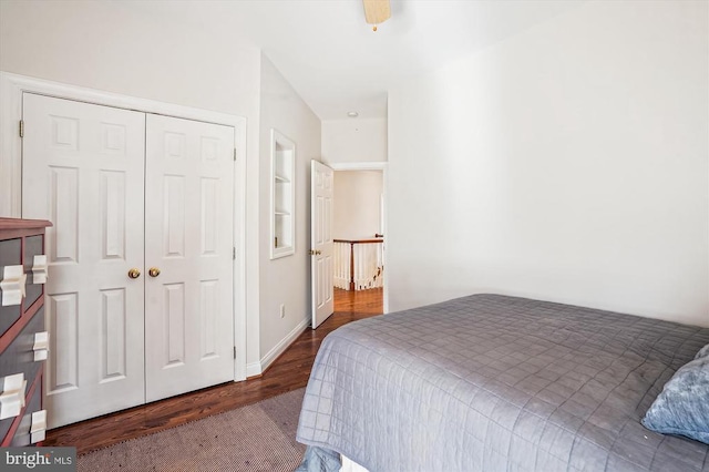 bedroom with wood finished floors, a closet, a ceiling fan, and baseboards