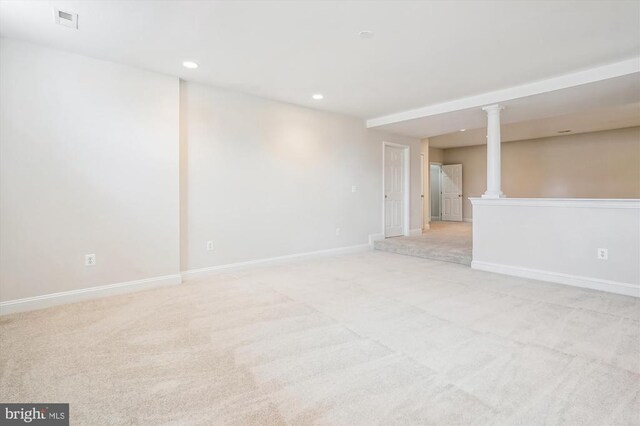 unfurnished room featuring light carpet, decorative columns, baseboards, and recessed lighting