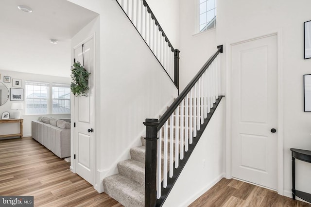 stairs featuring wood finished floors and baseboards