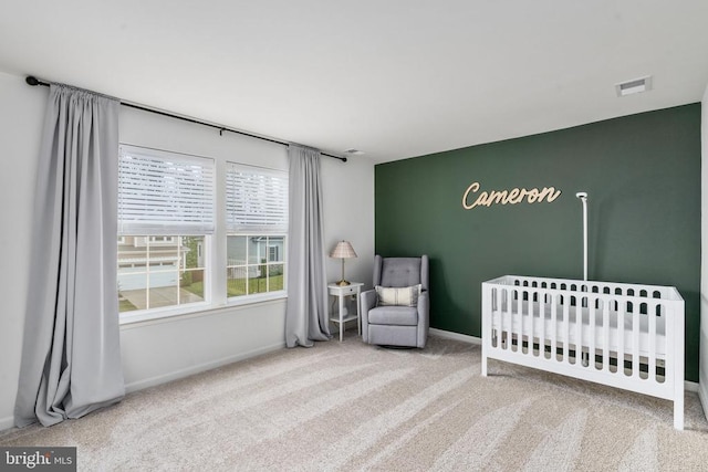 bedroom featuring carpet, a crib, and baseboards