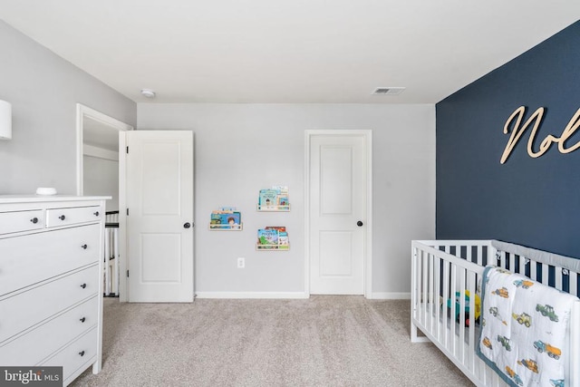 bedroom featuring light carpet, a nursery area, and baseboards