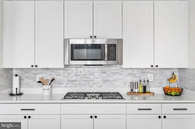 kitchen with appliances with stainless steel finishes, light countertops, and white cabinets
