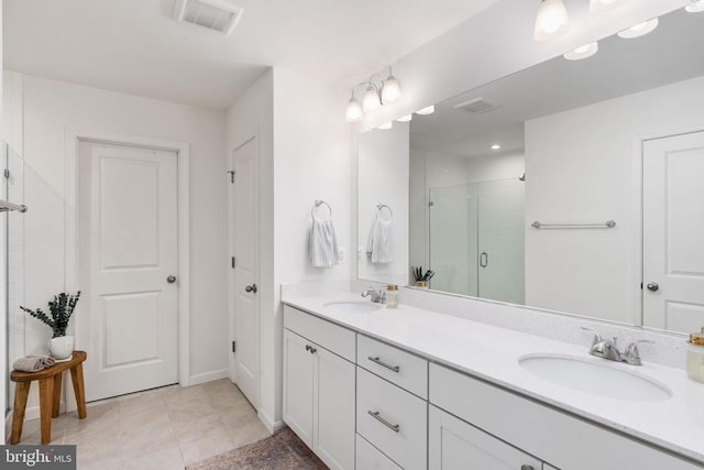 bathroom featuring a shower stall, double vanity, and tile patterned floors