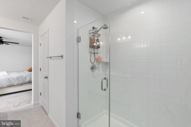 ensuite bathroom with a stall shower, a ceiling fan, baseboards, and tile patterned flooring