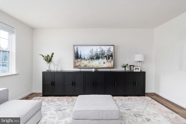 living area with wood finished floors and baseboards