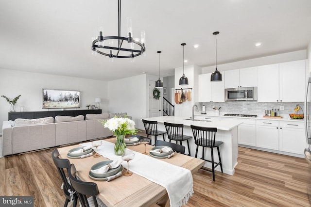 dining area with a chandelier, light wood-type flooring, and recessed lighting