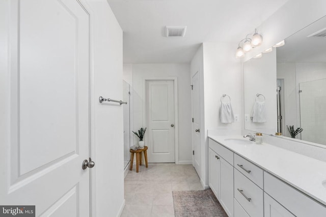 full bathroom with a shower stall, double vanity, tile patterned floors, and baseboards