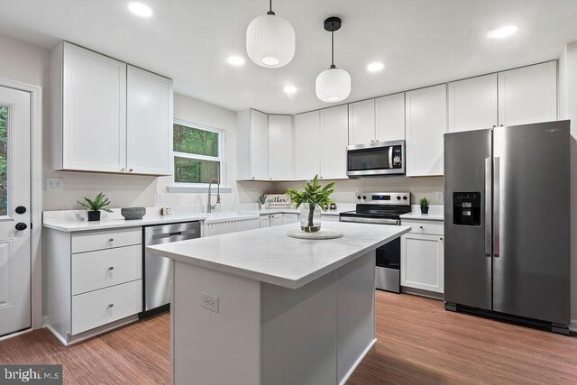 5925 Stubbs Bridge Rd, Mineral, VA 23117 - kitchen featuring appliances with stainless steel finishes, white cabinetry, pendant lighting, wood finished floors, and a kitchen island