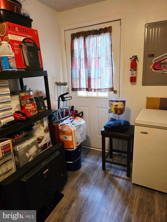 11708 Eisenhower Ln, Fredericksburg, VA 22407 - laundry area with dark wood-style flooring and electric panel