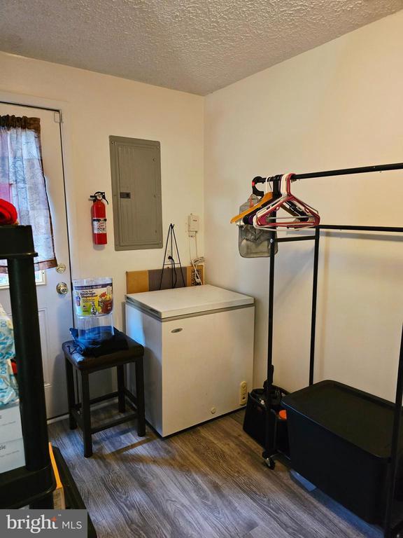 11708 Eisenhower Ln, Fredericksburg, VA 22407 - laundry room featuring wood finished floors, electric panel, and a textured ceiling