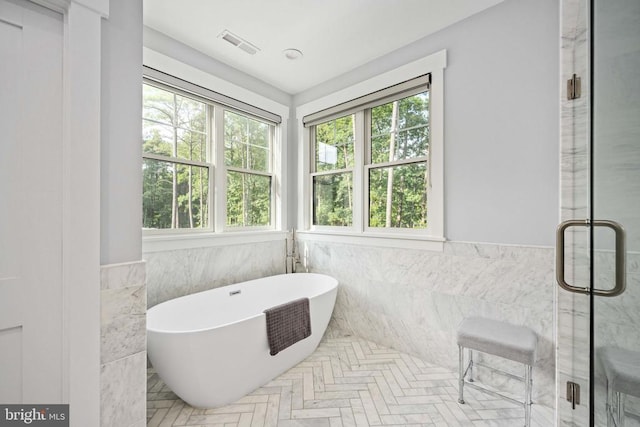 11606 Little Bay Harbor Way, Spotsylvania, VA 22551 - bathroom with tile walls, a freestanding tub, a shower stall, and a wainscoted wall