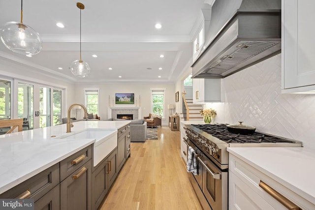 11606 Little Bay Harbor Way, Spotsylvania, VA 22551 - kitchen with range with two ovens, custom exhaust hood, white cabinetry, a lit fireplace, and recessed lighting