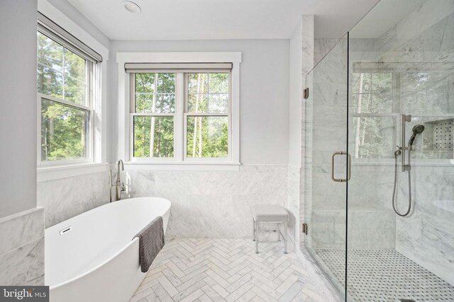 11606 Little Bay Harbor Way, Spotsylvania, VA 22551 - bathroom with plenty of natural light, a freestanding bath, tile walls, a shower stall, and wainscoting